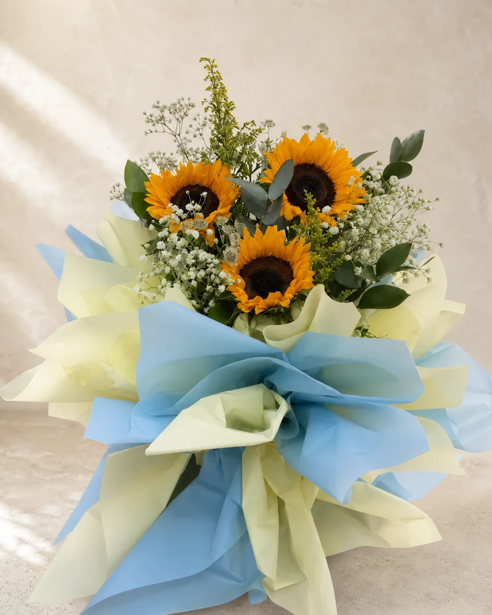 Hand-tied sunflower bouquet with eucalyptus, baby's breath and blue-and-cream wrapping